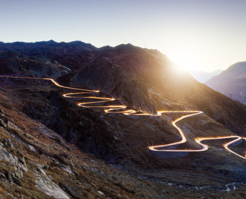 Sonnenaufgang am Gotthard - historische Passstrasse Tremola beleuchtet durch die Lichter von Autos
